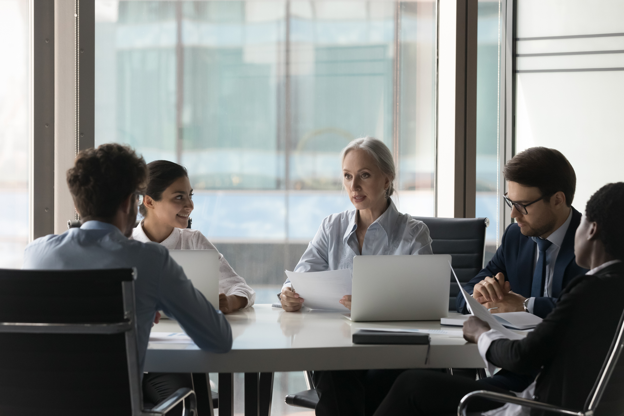 Diverse people take part in group meeting in office boardroom